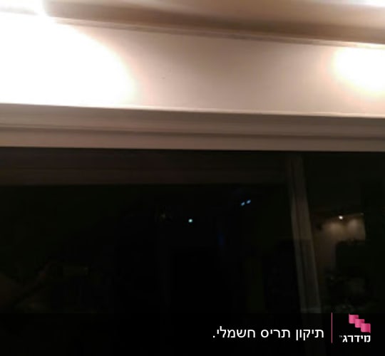 תריסים סגורים מעל חלון זכוכית גדול
